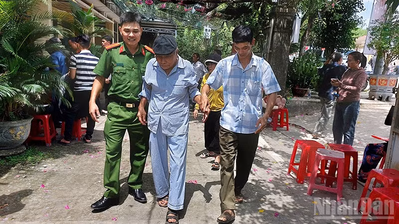 Cán bộ, chiến sĩ Công an xã Phú Ninh hỗ trợ người cao tuổi đi làm giấy tờ cá nhân.