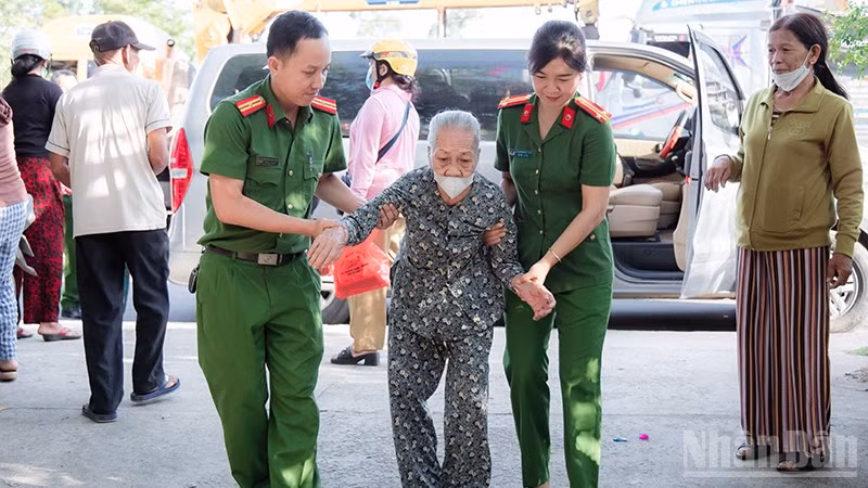 Cán bộ, chiến sĩ Công an xã Phú Ninh hỗ trợ người cao tuổi đi làm giấy tờ cá nhân.