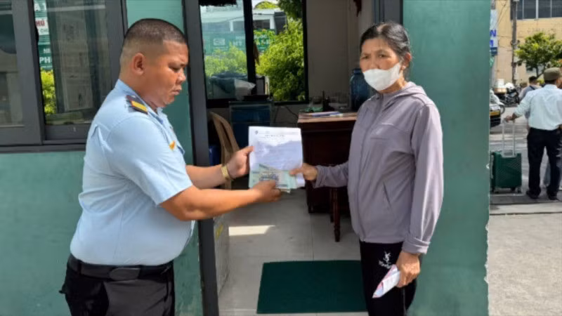 Bảo vệ tại Bệnh viện Đà Nẵng trao lại số tiền nhặt được cho bà Võ Thị Tiếng. (Ảnh: Bệnh viện Đà Nẵng cung cấp)