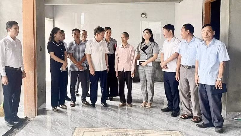 Ban Chỉ đạo xóa nhà tạm, nhà dột nát huyện Lâm Thao chia sẻ niềm vui với gia đình bà Nguyễn Thị Hữu (áo hồng đứng giữa) ở khu 5, xã Tứ Xã bên căn nhà mới.