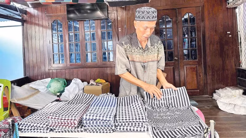 Nghệ nhân Mohamad giới thiệu các sản phẩm dệt truyền thống của người Chăm.