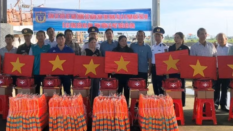 Đại biểu tham dự hội nghị tặng cờ Tổ quốc, áo phao, thiết bị y tế cho ngư dân. (Ảnh: HOÀNG TRUNG)