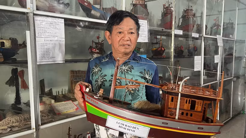 Nghệ nhân Nguyễn Văn Léo bên những chiếc tàu đánh cá gắn liền với cuộc đời mình. (Ảnh: HOÀNG TRUNG)