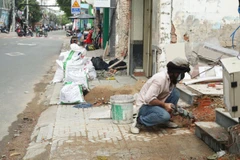 Người dân phường Vĩnh Hội bàn giao mặt bằng, sửa sang nhà ở chuẩn bị thi công Dự án cầu đường Nguyễn Khoái. (Ảnh: THẾ ANH)