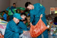 Lực lượng Dân quân tự vệ thuộc Ban chỉ huy Phòng thủ khu vực 2-Phú Lợi chuẩn bị nhu yếu phẩm gửi ra cho bà con bị ảnh hưởng lũ lụt ở miền trung. (Ảnh: VÕ LÊ) 
