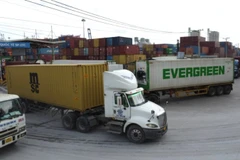 Xe container chở hàng hóa ra vào Cảng. (Ảnh: QUÝ HIỀN)