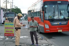 Lực lượng Công an kiểm tra chủ phương tiện xe khách tuyến đường dài. (Ảnh: QUÝ HIỀN)