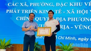 Chủ tịch Ủy ban nhân dân Thành phố Hồ Chí Minh Nguyễn Văn Được tặng bằng khen cho anh Cao Thành Đạt. (Ảnh: Vương Lê) 