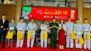 Lãnh đạo Bệnh viện Quân y 175 và nhà hảo tâm trao quà cho bệnh nhân có hoàn cảnh khó khăn đang điều trị tại bệnh viện. (Ảnh: Vương Lê)