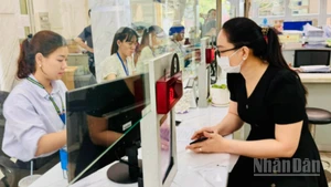 Cán bộ, công chức Thành phố Hồ Chí Minh giải quyết thủ tục hành chính cho người dân. (Ảnh: VƯƠNG LÊ) 