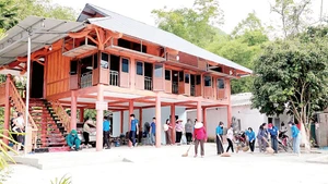 Người dân giúp gia đình ông Nguyễn Viết Đôn ở thôn Đồng Kem, xã Đồng Yên, Tuyên Quang dọn vào nhà mới. (Ảnh: TRỊNH KHÁNH TOÀN)