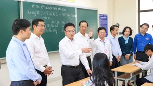 Phó Thủ tướng Lê Thành Long thăm hỏi, động viên các thí sinh đang nghe quy chế, hướng dẫn thủ tục thi.