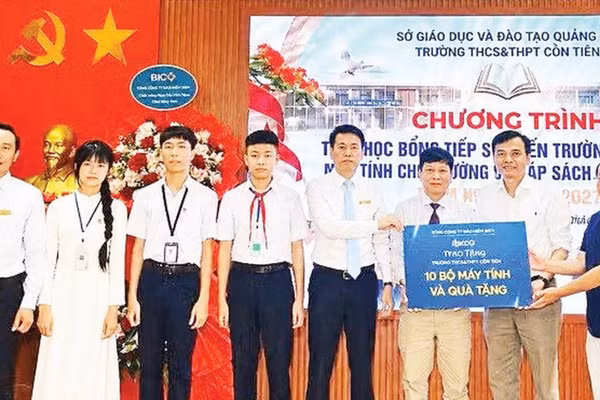 Đại diện Công ty cổ phần Kaopiz Holdings và Báo Nhân Dân trao máy tính tặng Trường THCS & THPT Cồn Tiên (Ảnh QUANG HUY)
