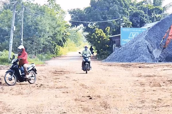 Mặt đường nhựa bị vật liệu rơi vãi biến thành con đường đất, nắng thì bụi, mưa thì sình lầy.