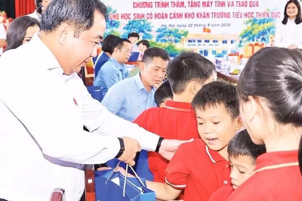 Bí thư Thành ủy Hà Nội Trần Đức Thắng tặng quà học sinh có hoàn cảnh khó khăn tại Trường tiểu học Thiên Đức, xã Phù Đổng (Ảnh THÁI QUANG)