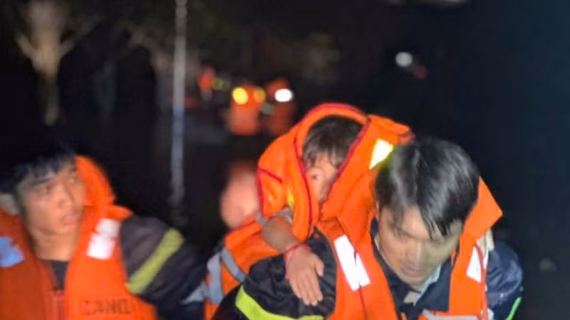 Lực lượng cứu hộ đưa người dân và trẻ em ra khỏi vùng ngập lụt. 