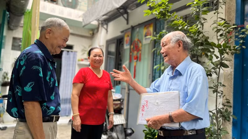 Ông Nguyễn Khắc Êm (áo xanh) trò chuyện cùng người dân trong khu phố. 