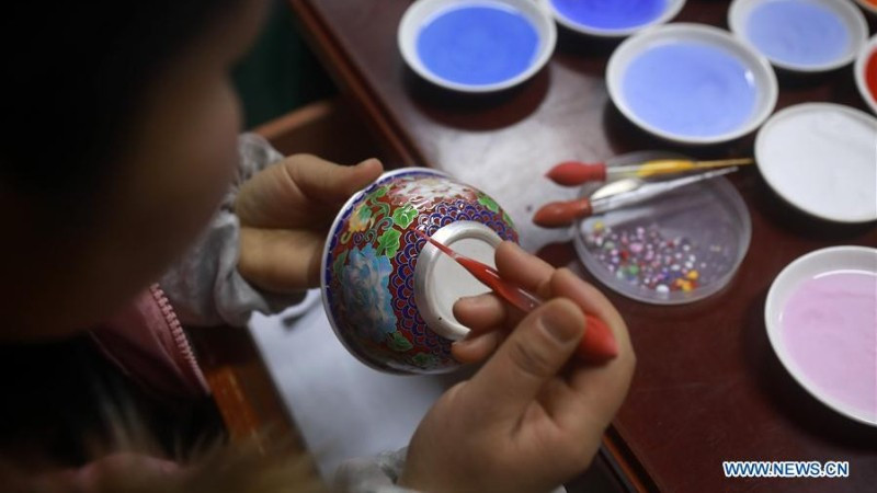 Nghệ nhân đang tráng men cho một chiếc bát bạc ở tỉnh Quý Châu, tây nam Trung Quốc. (Ảnh: Xinhua)
