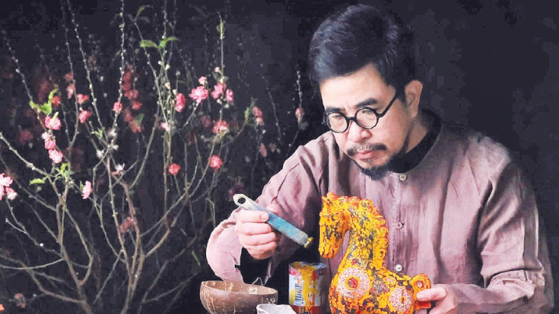 Nghệ nhân Nguyễn Tấn Phát trong quá trình sáng tạo tác phẩm sơn mài ngựa Bính Ngọ 2026. (Ảnh MINH NGUYỄN)