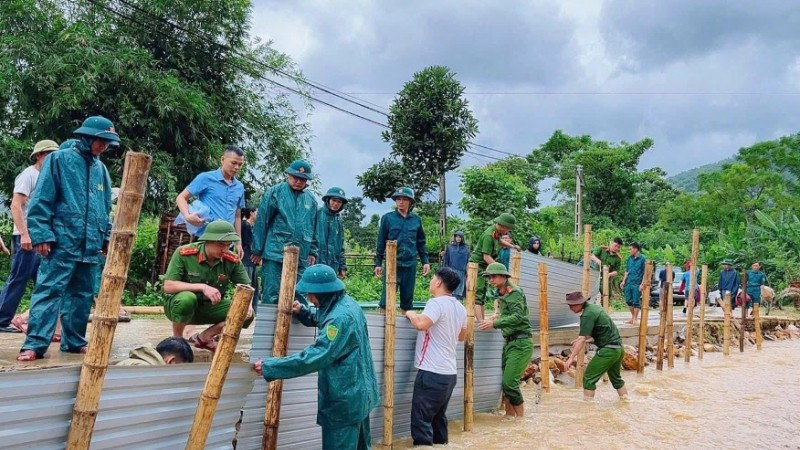 Công an xã Hùng Chân, tỉnh Nghệ An phối hợp chính quyền địa phương và nhân dân khắc phục tuyến đường qua bản Luông bị xói lở do mưa bão gây ra. (Ảnh ĐÌNH PHƯỢNG)