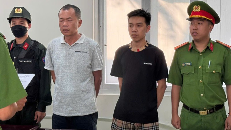 Đặng Trần Quốc Vũ (áo trắng) và Đào Năng Nghĩa (áo đen) tại cơ quan Công an. 