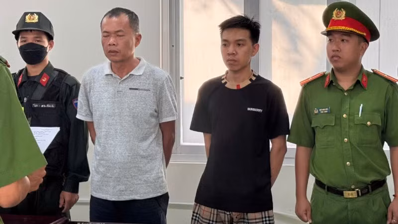 Đặng Trần Quốc Vũ (áo trắng) và Đào Năng Nghĩa (áo đen) tại cơ quan Công an. 