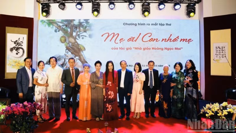 Tác giả tập thơ, nhà giáo Hoàng Thị Ngọc Mai (áo dài đỏ) cùng các đại biểu dự sự kiện.