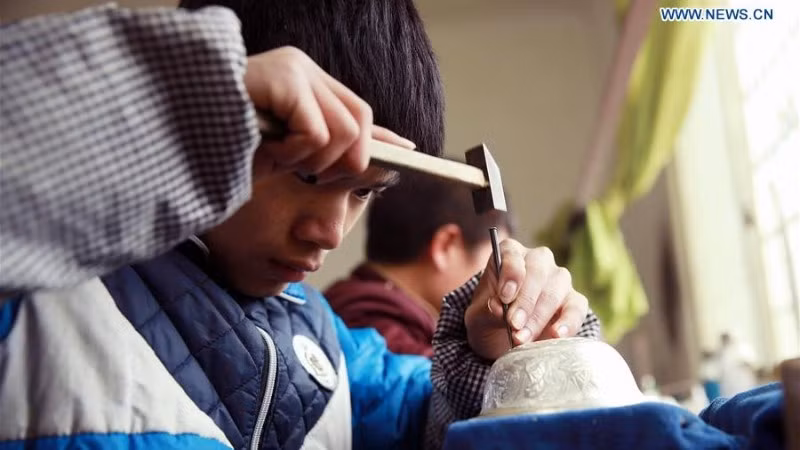 Thợ thủ công chế tác trang sức bạc tại tỉnh Quý Châu, tây nam Trung Quốc. (Ảnh: Xinhua)