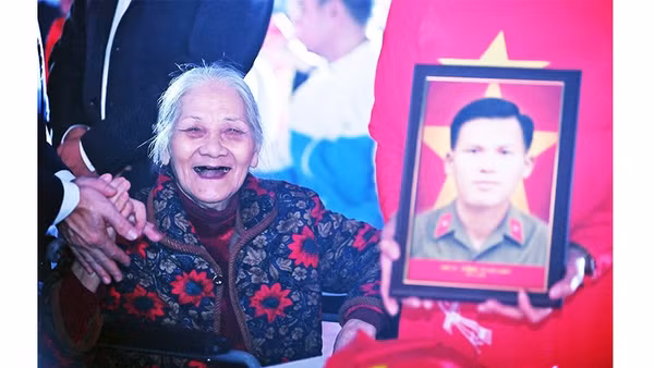 Khoảnh khắc bà Nguyễn Thị Bích cười tươi khi đón di ảnh của người bạn đời.