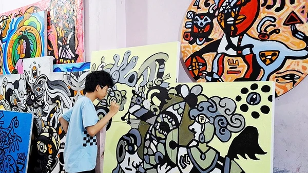 Hoàng Nhật Quang bên tác phẩm của mình.