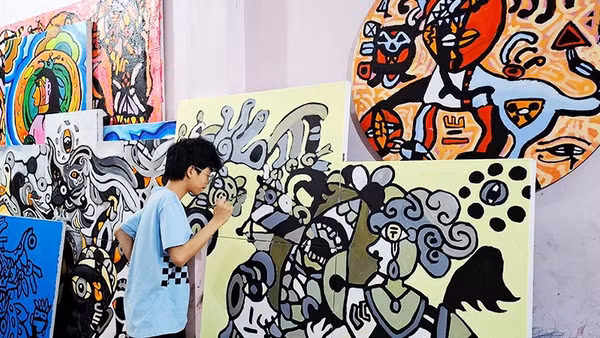 Hoàng Nhật Quang bên tác phẩm của mình.