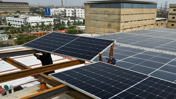 Các kỹ thuật viên lắp đặt tấm pin mặt trời trên mái nhà của một nhà máy ở thành phố cảng Karachi của Pakistan. Ảnh: AFP