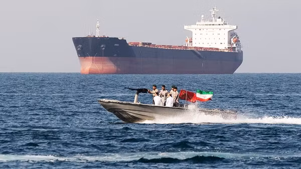 Lực lượng an ninh Iran tuần tra cạnh một tàu hàng ở Eo biển Hormuz. Ảnh: GETTYIMAGES