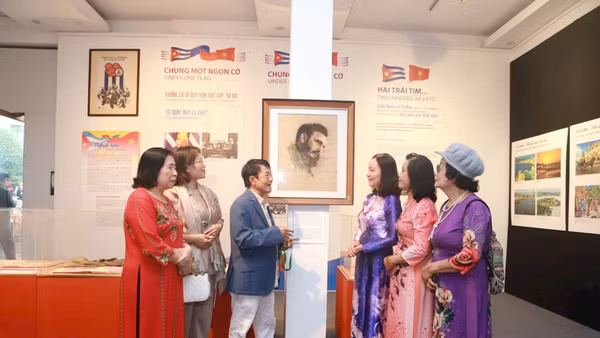Nhà báo Huỳnh Dũng Nhân (thứ ba, trái sang) giới thiệu bức vẽ kỷ vật gia đình trao tặng Bảo tàng Phụ nữ Việt Nam.