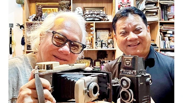 Đạo diễn Xuân Phước (phải) với tác giả bài viết chuẩn bị đạo cụ cho dòng phim xưa. Ảnh tư liệu của người viết