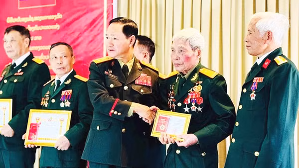 Thượng tướng Khamliang Outhakaysone - Bộ trưởng Quốc phòng Lào chụp ảnh lưu niệm cùng Trung tá Nguyễn Cao Phong và các bộ đội tình nguyện tại Lào. Ảnh: NVCC