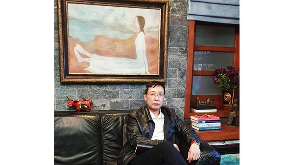 Nhà sưu tầm Hoàng Anh Tuấn bên tác phẩm của họa sĩ Dương Bích Liên.
