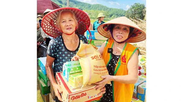 Bà Nguyệt đi phát gạo cho người dân vùng ngập nước.