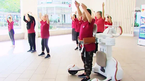 Ông Leow Cher Hwa tham gia lớp học Zumba với sự hỗ trợ trực tiếp từ robot hỗ trợ vận động. Ảnh: CNA
