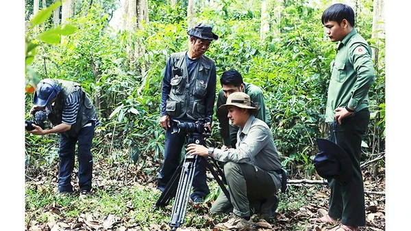 Đạo diễn Tú Anh (ngồi sau máy quay) trong một lần quay ngoại cảnh. Ảnh: NVCC