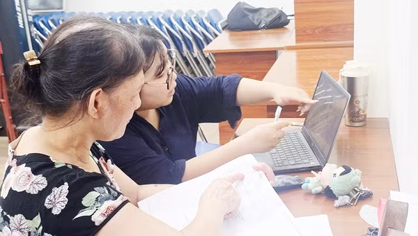 Hướng dẫn người dân cập nhật dữ liệu đất đai tại cụm dân cư. Ảnh: NGUYỆT ANH