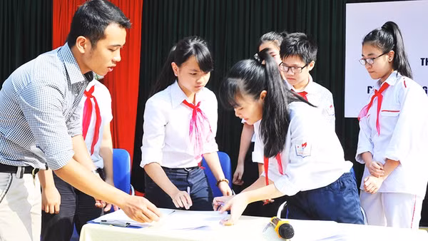 Các em học sinh ký cam kết phòng chống tệ nạn xã hội trong trường học. Ảnh: NAM HẢI