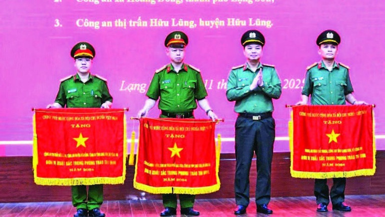 Giám đốc Công an tỉnh trao Cờ thi đua của Chính phủ cho ba tập thể đã có thành tích xuất sắc. (Ảnh VIỆT DŨNG)