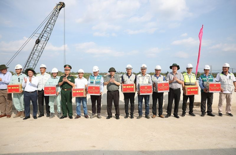 Thủ tướng Phạm Minh Chính thăm, động viên công nhân, kỹ sư thi công dự án đường bộ cao tốc Cần Thơ-Cà Mau đoạn qua thành phố Cà Mau. (Ảnh: Dương Giang/TTXVN)