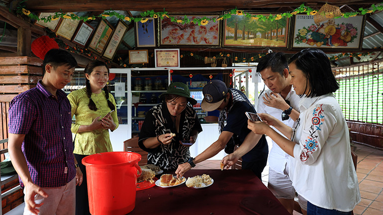 Anh Phạm Duy Khanh, chủ cơ sở du lịch cộng đồng Mười Ngọt (ngoài cùng bên trái), hướng dẫn khách thưởng thức ong non khai thác từ rừng U Minh Hạ. Anh Phạm Duy Khanh, chủ cơ sở du lịch cộng đồng Mười Ngọt (ngoài cùng bên trái), hướng dẫn khách thưởng thức ong non khai thác từ rừng U Minh Hạ.