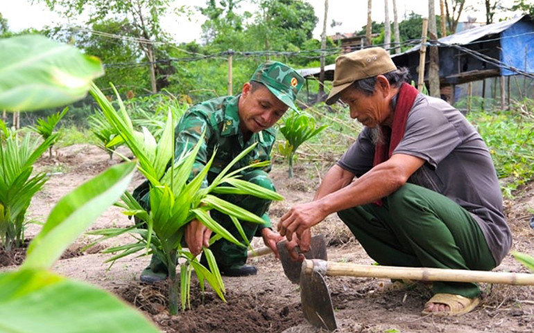 Cán bộ Đồn Biên phòng Dục Nông (Bộ Chỉ huy Bộ đội Biên phòng tỉnh Kon Tum) hướng dẫn người dân canh tác cây trồng. (Ảnh MAI HƯƠNG)
