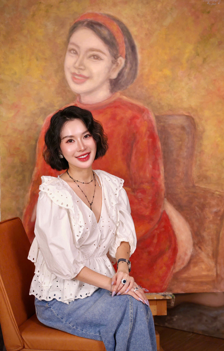 Họa sĩ Đặng Thanh Huyền bên một tác phẩm vẽ chính mình.