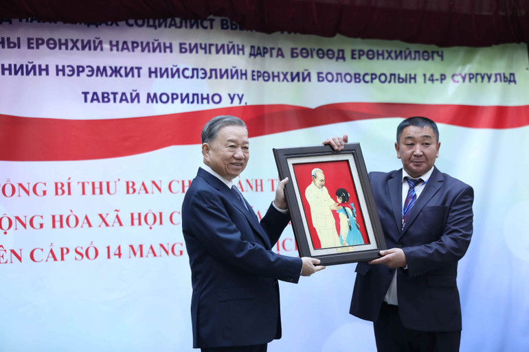 Tổng Bí thư, Chủ tịch nước tặng bức ảnh Bác Hồ với thiếu nhi cho Hiệu trưởng nhà trường. (Ảnh: NGUYỄN HỒNG) Tổng Bí thư, Chủ tịch nước tặng bức ảnh Bác Hồ với thiếu nhi cho Hiệu trưởng nhà trường. (Ảnh: NGUYỄN HỒNG)