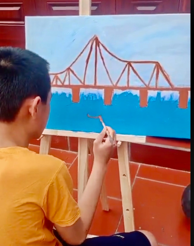 Tạ Đức Bảo Nam say sưa vẽ những cây cầu yêu thích. (Ảnh: VĂN CHỨC)