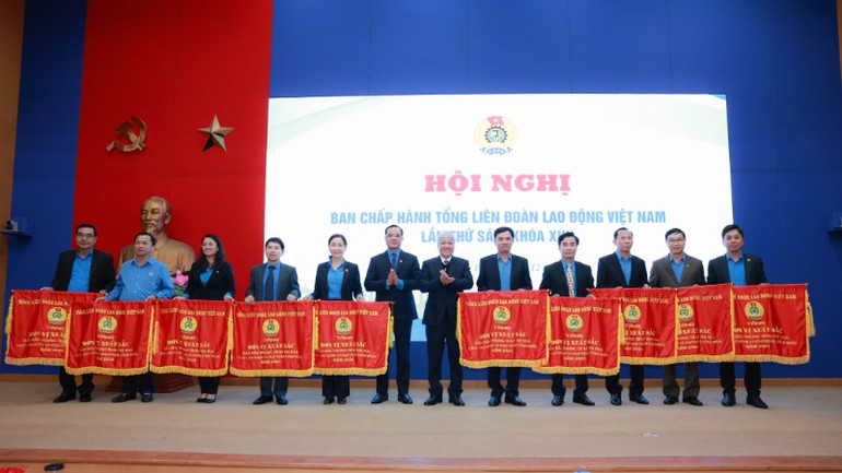 Các đồng chí Đỗ Văn Chiến và Nguyễn Đình Khang trao cờ thi đua của Tổng Liên đoàn Lao động Việt Nam tặng 10 tập thể có thành tích xuất sắc trong năm 2024.